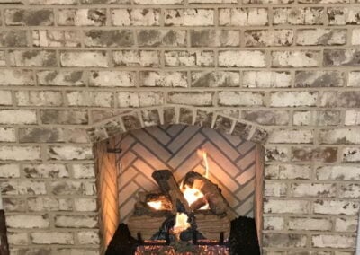 distressed white brick open fireplace with gas logs