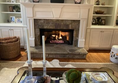 ornate living room with stone fireplace with gas logs