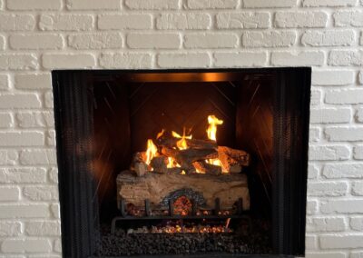 white brick fireplace with gas logs