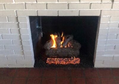 white brick fireplace with gas logs